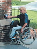lady in wheelchair using access control equipment. Assessability specialises in assessing disability access requirements.