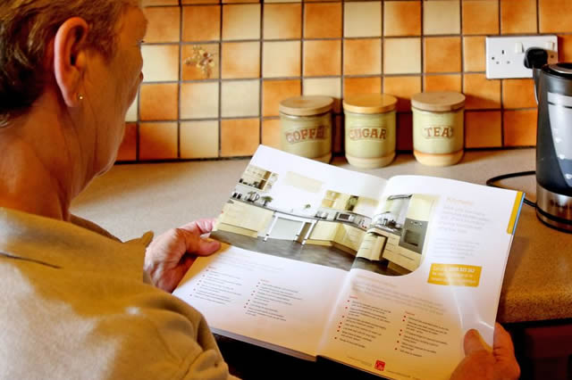 lady studying brochure showing kitchen disability adaptations