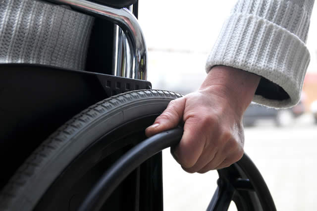 close up of a person's hand on a wheelchair wheel